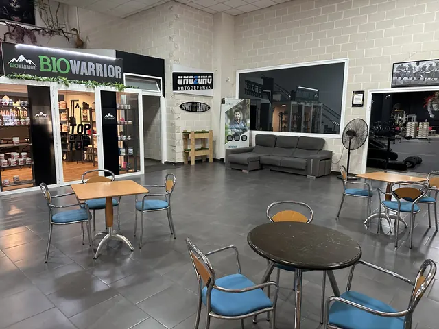Zona de mesas y descanso con la tienda BioWarrior al fondo