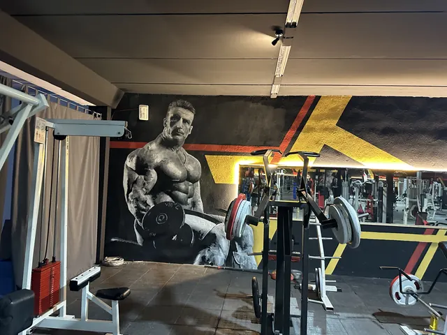 Sala de máquinas con mural y equipamiento de fuerza